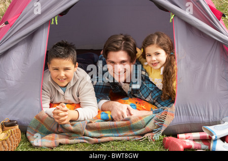 Young Family Relaxing Inside Tent On Camping Holiday Stock Photo