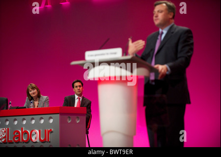 Labour leader Ed Miliband and MP Harriet Harman look on as Ed Balls addresses delgates attending the Labour Party Conference in Stock Photo