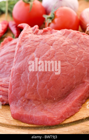 Raw beef fillet with vegetable as closeup on chopping bread Stock Photo