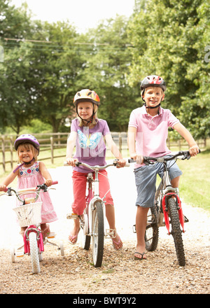 Children In Countryside Wearing Safety Helmets Stock Photo