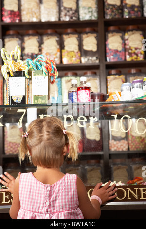 Excited Girl Standing In Sweet Shop Stock Photo