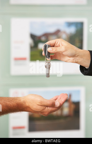 Close Up Of Estate Handing Over Keys Of New Home To Client Stock Photo