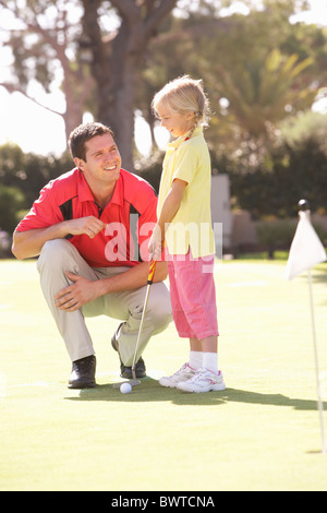 Father Teaching Daughter Play Golf Putting Green Stock Photo