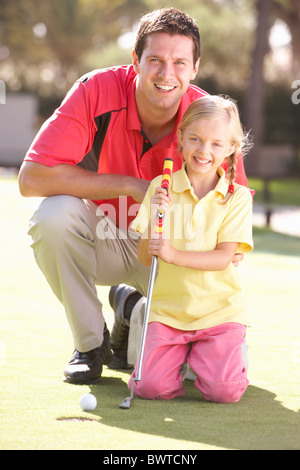 Father Teaching Daughter Play Golf Putting Green Stock Photo