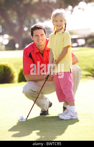 Father Teaching Daughter Play Golf Putting Green Stock Photo