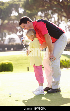 Father Teaching Daughter Play Golf Putting Green Stock Photo