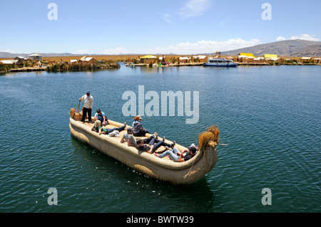 Tourists enjoying a ride on a reed boat around the floating Uros Islands of Lake Titicaca, one of Peru's top sight. Stock Photo