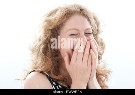 woman laughing with hands over mouth Stock Photo