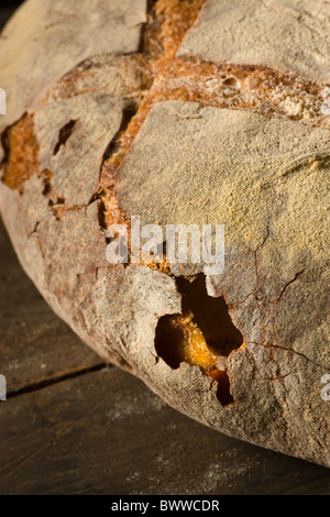 A loaf of artisanal bread on a rustic wood surface. Stock Photo