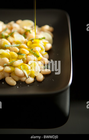 Boiled white beans served with garlic, sage and Extra virgin olive oil Stock Photo