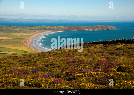 View from the slopes of Mynnyd Rhiw, on The Llyn Peninsula, across heather and gorse towards Porth Neigwl or Hell's Mouth. Stock Photo