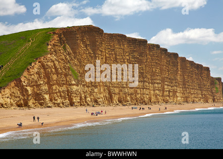 People on beach by West Bay Cliffs, Jurassic Coast World Heritage Site, West Bay, Bridport, Dorset, England, United Kingdom Stock Photo