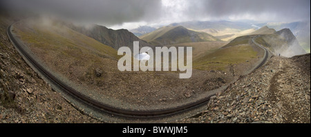 Panorama of Snowdon Mountain Railway track curving round ascent to Snowdon summit. Llyn Du Arddu and Clogwyn Station visible Stock Photo