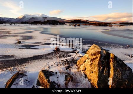 Looking across a frozen lochan nah-achlaise to the peaks of the Blackmount range of mountains in winter. Stock Photo
