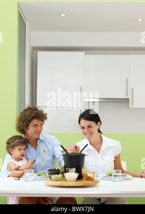 family eating meat fondue at home. Copy space Stock Photo