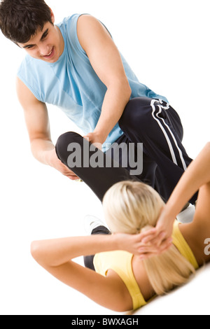 Photo of sportswoman doing physical exercise with help of instructor Stock Photo