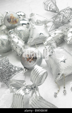 Silver Christmas decorations on white table cloth. Stock Photo
