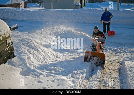 Young Boy Digging out from Snow Storm - Ithaca NY - Using snow blower to clear driveway after 17 inch overnight snow - February Stock Photo