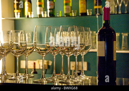 Wine bottle and wine glasses sitting on bar counter in restaurant Stock Photo