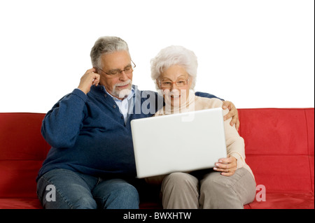 elderly couple on the sofa using a laptop Stock Photo