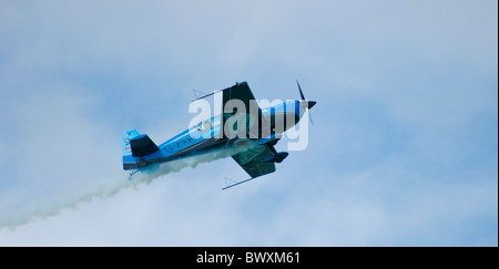 One single Blades extra 300 display plane climbing up from left to right of shot trailing smoke Stock Photo