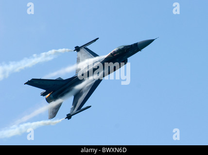 Belgian F-16A F16 in flight travelling left to right trailing smoke and lots of condensation  - cockpit visible Stock Photo