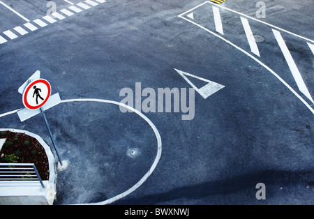 Overhead view of white markings on road with mini roundabout. Stock Photo