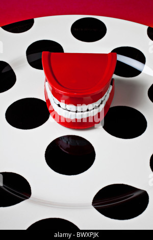 Toy teeth on poka dot plate Stock Photo