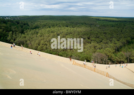 Tourists walking over the Great Dune of Pyla with the Landes forest visible in the background, France. Stock Photo