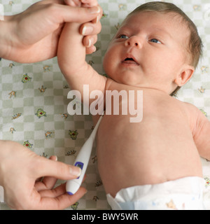 Woman Taking Baby's Temperature with Digital Thermometer
