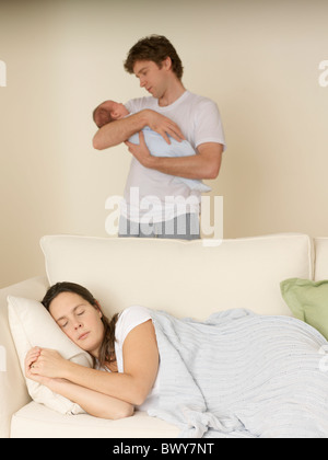 Mother Sleeping and Father with Baby Stock Photo