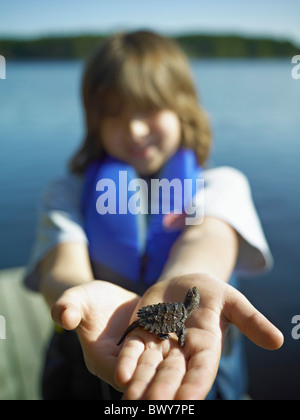 Boy holding Baby Snapping Turtle, Cache Lake, Algonquin Park, Ontario, Canada