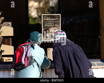 Two old ladies reading an advert in local library window, Bude, Cornwall, UK Stock Photo