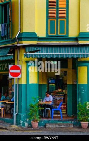 Ethnic male sitting at table in outdoor restaurant in Little India Singapore Stock Photo