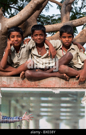 Rural Indian village school boys sitting on their school wall. Andhra Pradesh, India Stock Photo