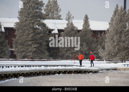 USA, Wyoming. Yellowstone National Park, Upper Geyser Basin. Tourists walking near Old Faithful Snow Lodge in winter. Stock Photo