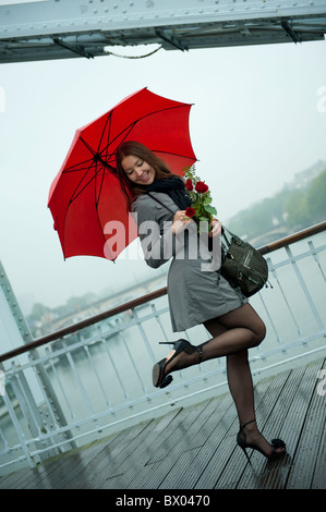 Caucasian woman in high heel shoes with red umbrella Stock Photo