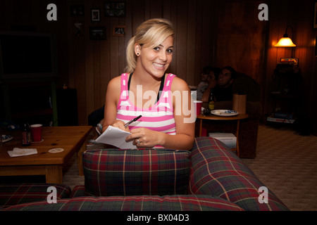 A happy, smilying woman holding a pen and paper. Stock Photo