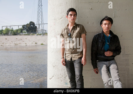 Serious teenage boys leaning against wall Stock Photo