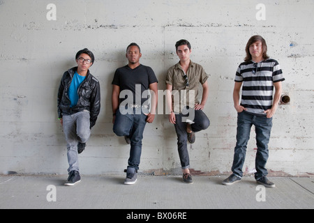 Serious teenage boys leaning against wall Stock Photo