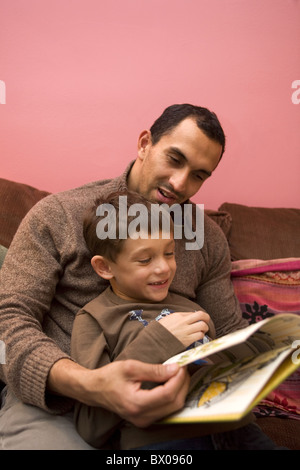 Father and son read a book together. (Child is Guatemalan and Polish living in America) Stock Photo