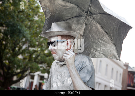 A man, painted in silver and standing still as a statue, performs for tips in New Orleans, Louisiana. Stock Photo
