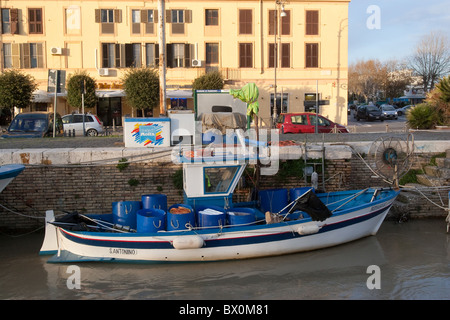 old aged fishing boat moored in canal of Tiber river in Fiumicino Rome, Mediterranean Italian European Stock Photo