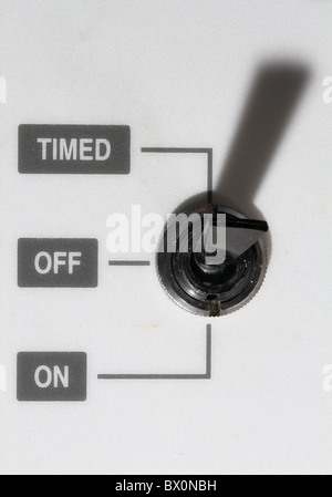 Toggle switch on heating control system with timed, on and off settings. Stock Photo