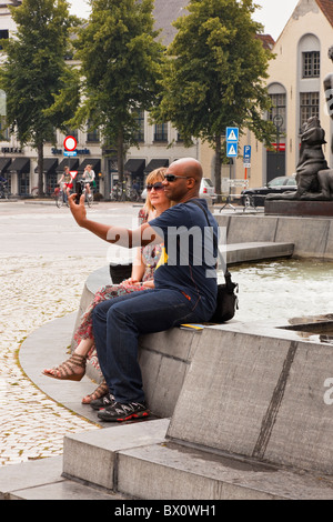 Het Zand, Bruges, East Flanders, Belgium, Europe. Mixed race couple photographing themselves Stock Photo
