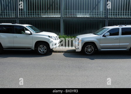Two SUVs: Jeep Grand Cherokee 3.0 CRD V6 and Toyota Land Cruiser 3.0 D-4D V6 - city road Stock Photo