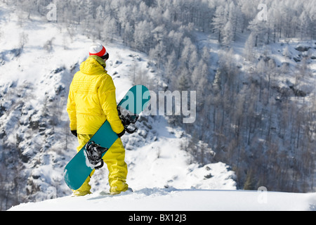Rear view of snowboarder standing in snowdrift in winter Stock Photo