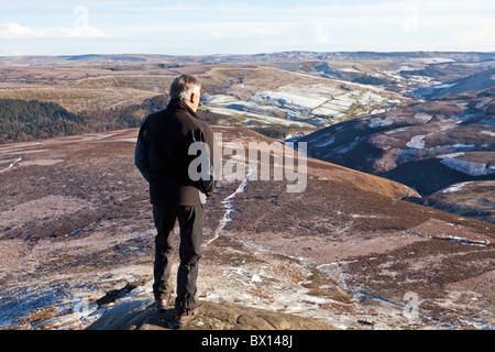 A male walker by Fairbrook in winter on Kinder Scout in the Dark Peak ...