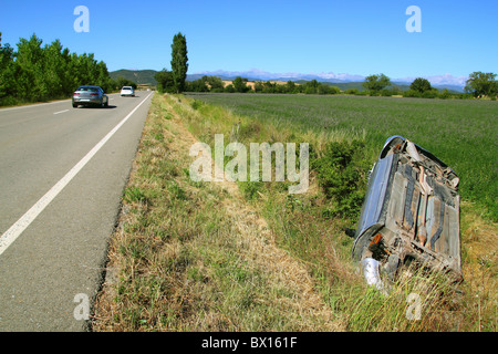 Car crash accident upside down vehicle off the road green landscape Stock Photo