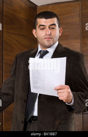 30 years old Middle Eastern Businessman reading a paper inside office Beirut Lebanon Middle East Stock Photo